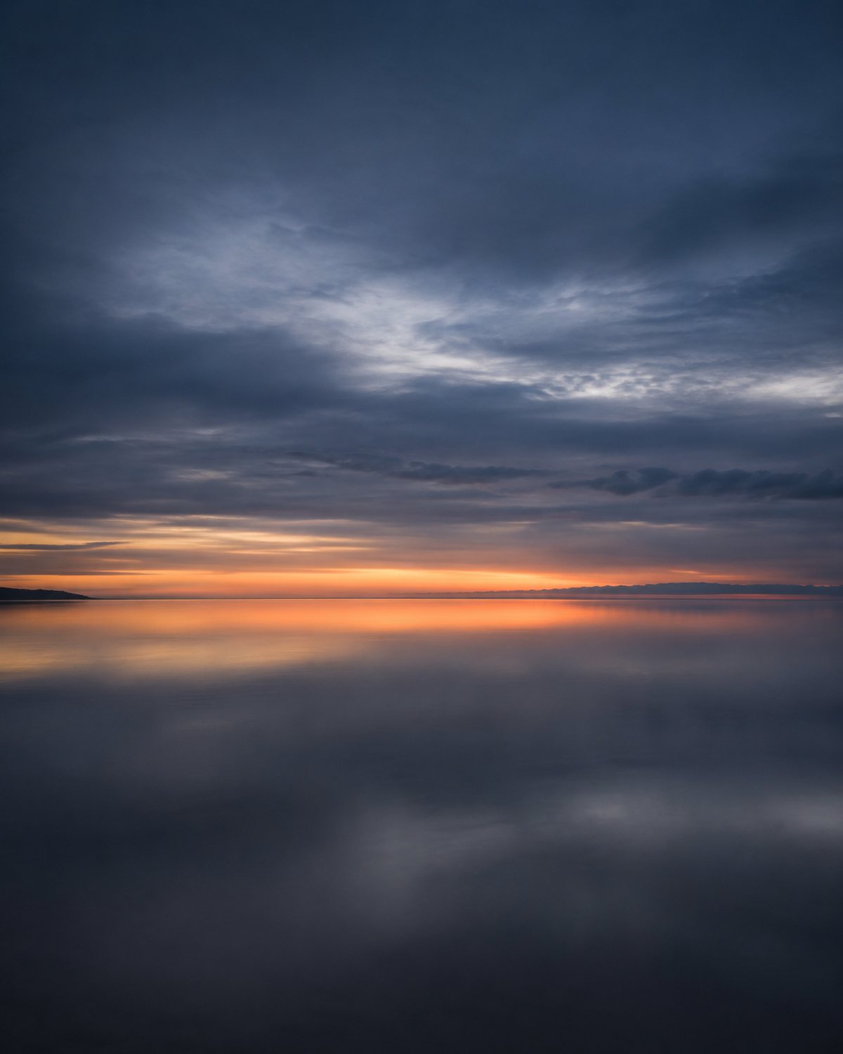 A soft blue horizon with warm light stretching across the sky